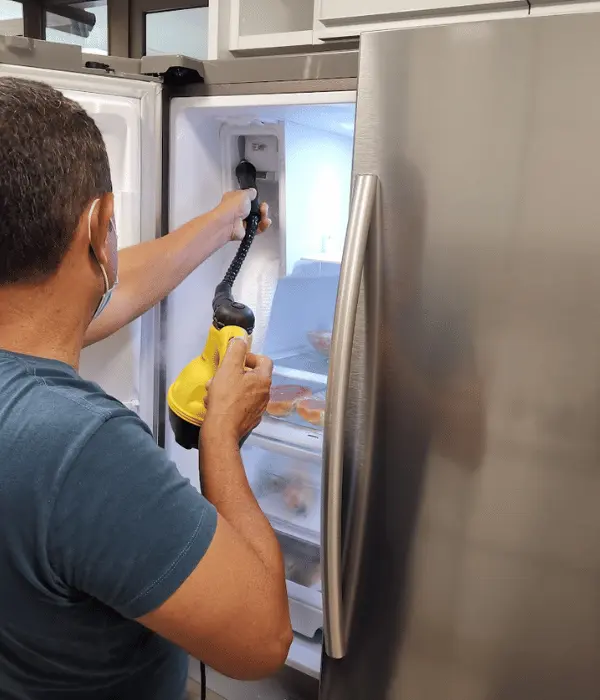 Técnico realizando reparo na geladeira Samsung