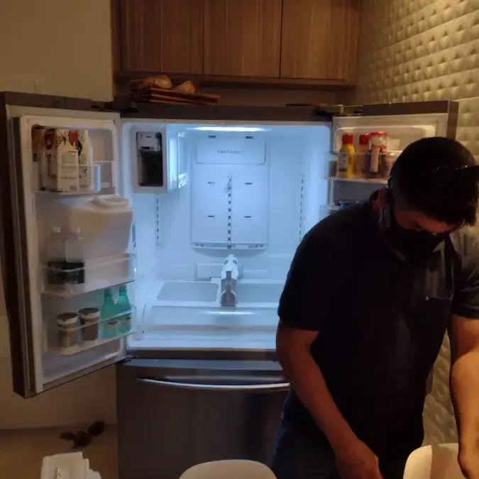 Técnico em refrigeração realizando conserto de geladeira